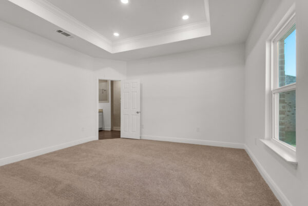 The master bedroom with coffer ceiling in the Ariana floorplan from the Cornerstone collection by Holiday Builders.