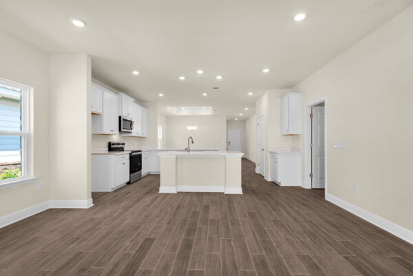 The living area facing the kitchen of the Bay floorplan from the Cornerstone Collection by Holiday Builders.