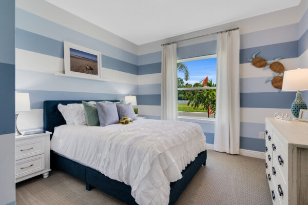 A blue-striped bedroom in the Biscayne floorplan from the Cornerstone collection by Holiday Builders.