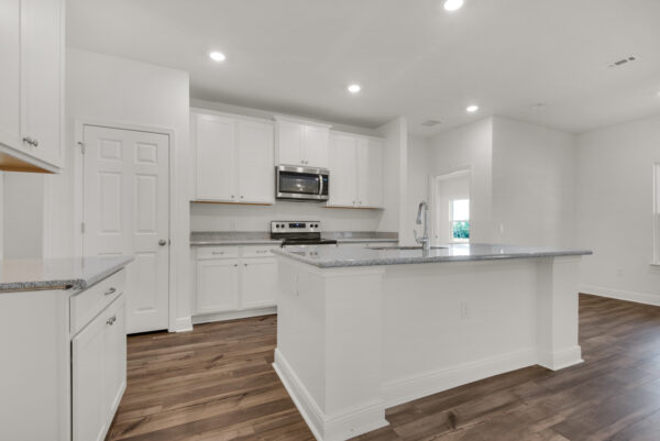 An all white kitchen in the Caliza floorplan from the Cornerstone collection by Holiday Builders.