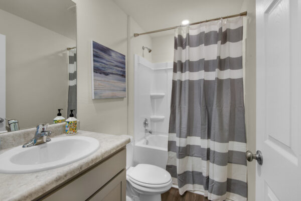 A gray striped guest bath in the Grayton floorplan from the Value collection by Holiday Builders.