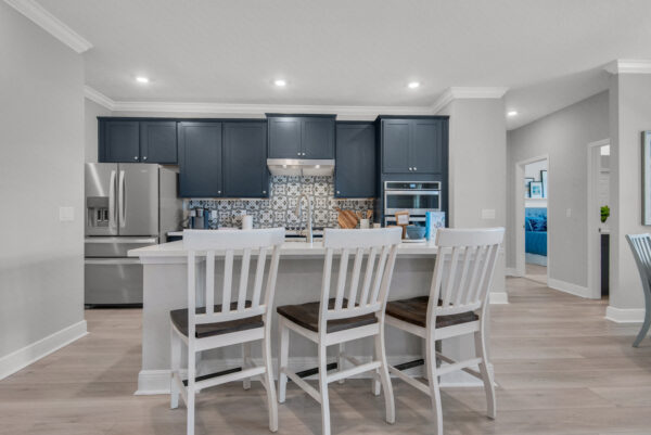A beautiful blue kitchen in the Hamilton floorplan from the Cornerstone collection by Holiday Builders.