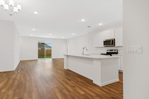 The kitchen and living areas in the Naples floorplan from the Cornerstone collection by Holiday Builders.