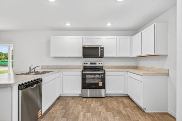 The kitchen with stainless steel appliance in the Palmetto floorplan from the Value Collection by Holiday Builders
