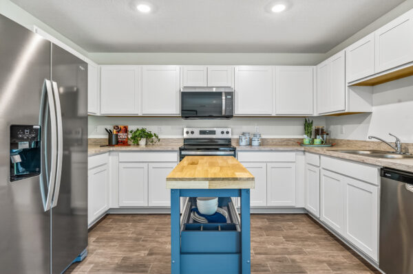 The kitchen with island in the Queen floorplan from the Value Collection by Holiday Builders